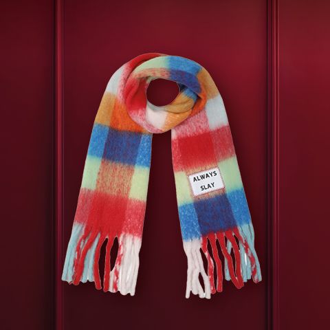 Un molinillo de pimienta de madera sobre un fondo rojo oscuro. En el cuerpo del molinillo hay un texto grabado. En la parte superior de la imagen está la frase "REGALOS SOSTENIBLES".