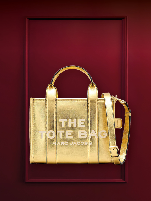 Un bolso estructurado de metal con asas sobre un fondo burdeos. Encima está la palabra "BOLSO DE LOS DESEOS".