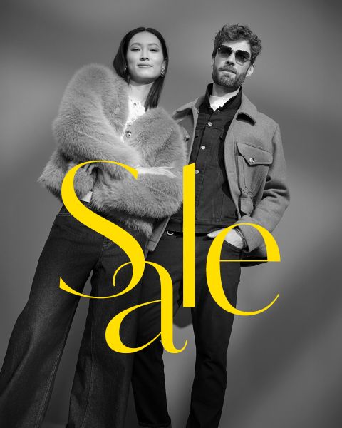 Una mujer elegante con un abrigo de piel y un hombre con gafas de sol y chaqueta posan con confianza. La foto en blanco y negro está superpuesta con la inscripción amarilla en negrita "Rebajas".